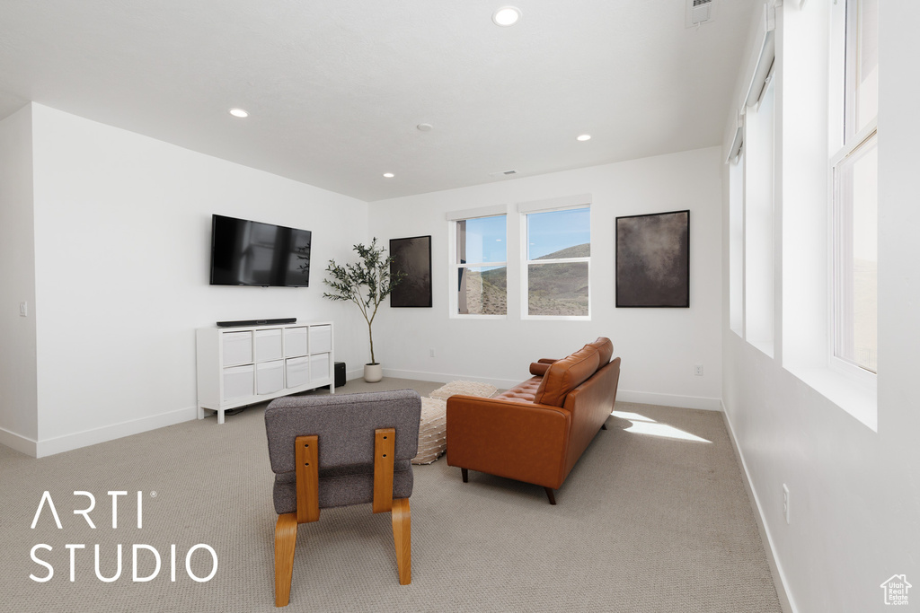 Carpeted living room with recessed lighting and baseboards