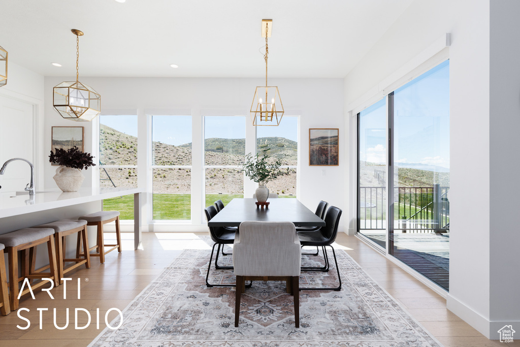 Dining space featuring an inviting chandelier, recessed lighting, light wood finished floors, and a mountain view