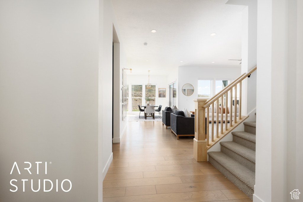 Corridor with recessed lighting, light wood finished floors, and stairs