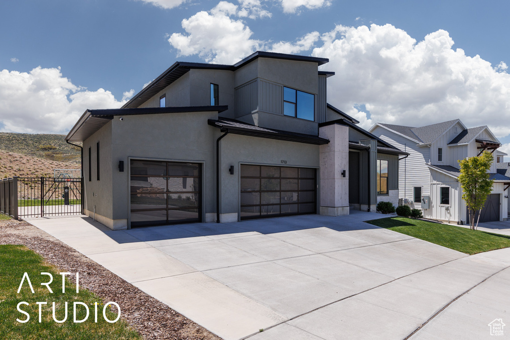 Contemporary home featuring stucco siding, fence, and concrete driveway