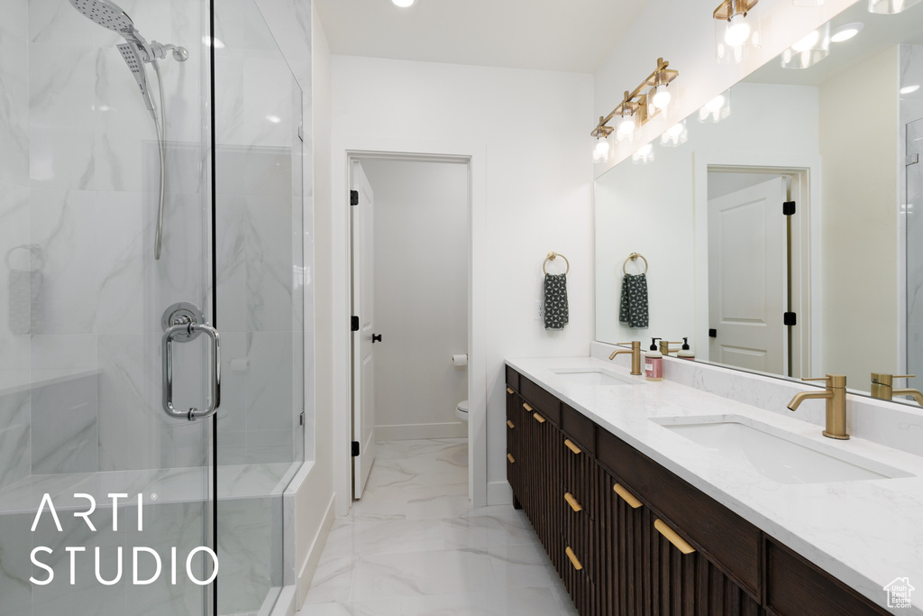Bathroom with a sink, a shower stall, toilet, and marble finish floor