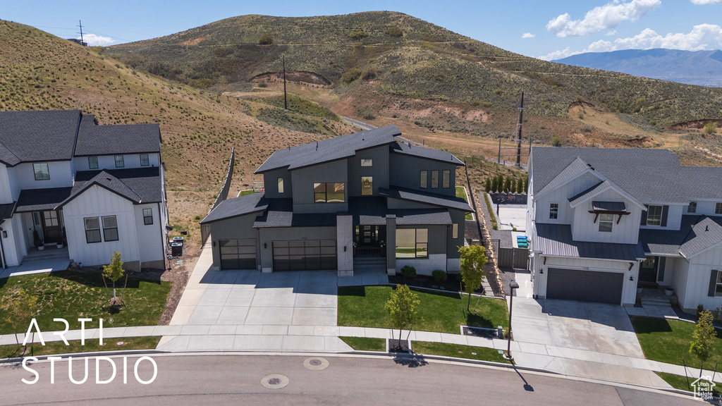 View of front of home featuring concrete driveway, a mountain view, and a garage