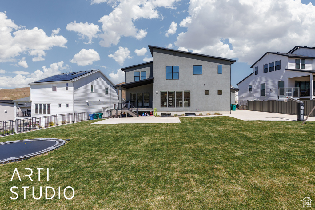 Rear view of property with a yard, a patio, and fence