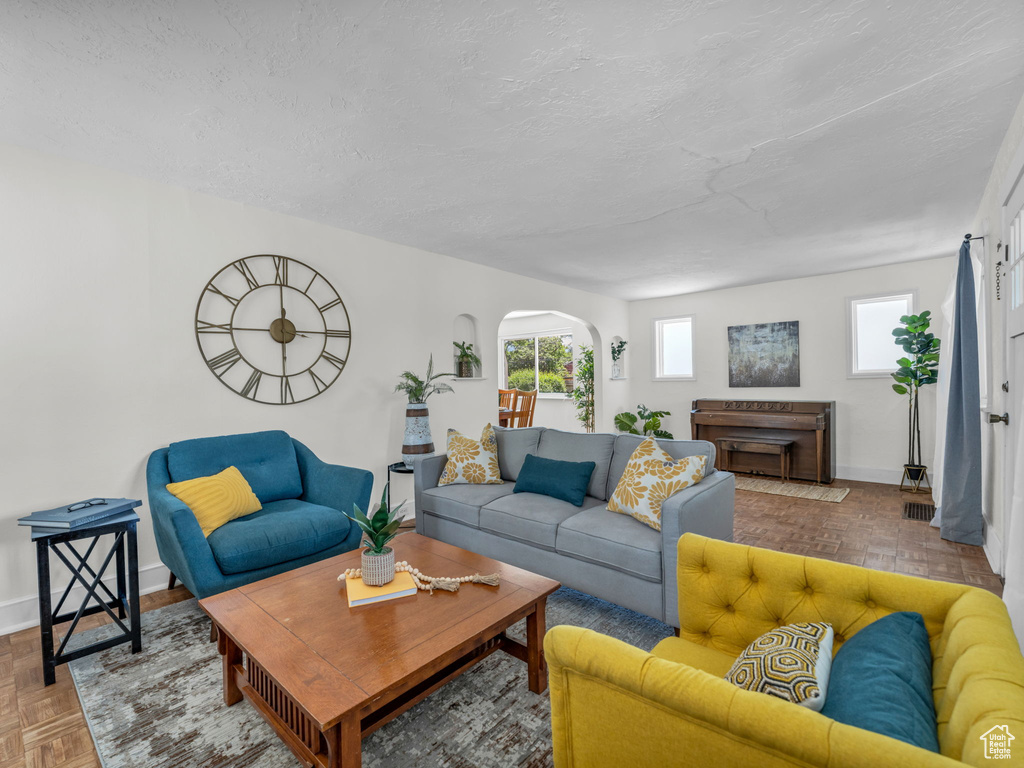 Living area featuring a textured ceiling, baseboards, and a fireplace
