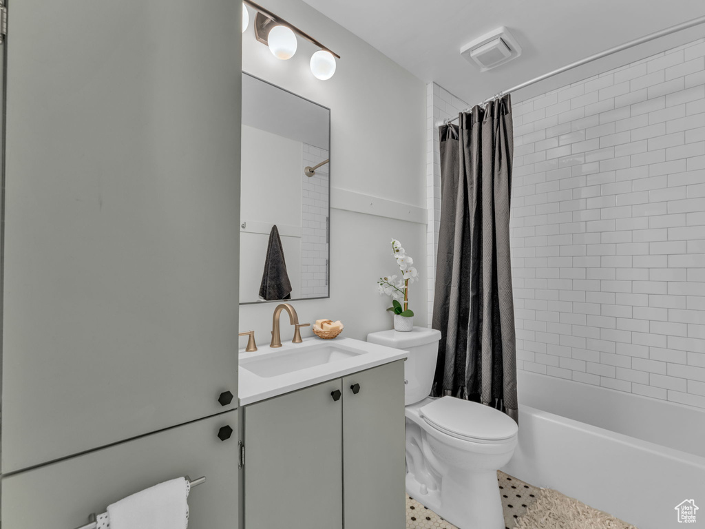 Full bath with toilet, vanity, and shower / bathtub combination with curtain