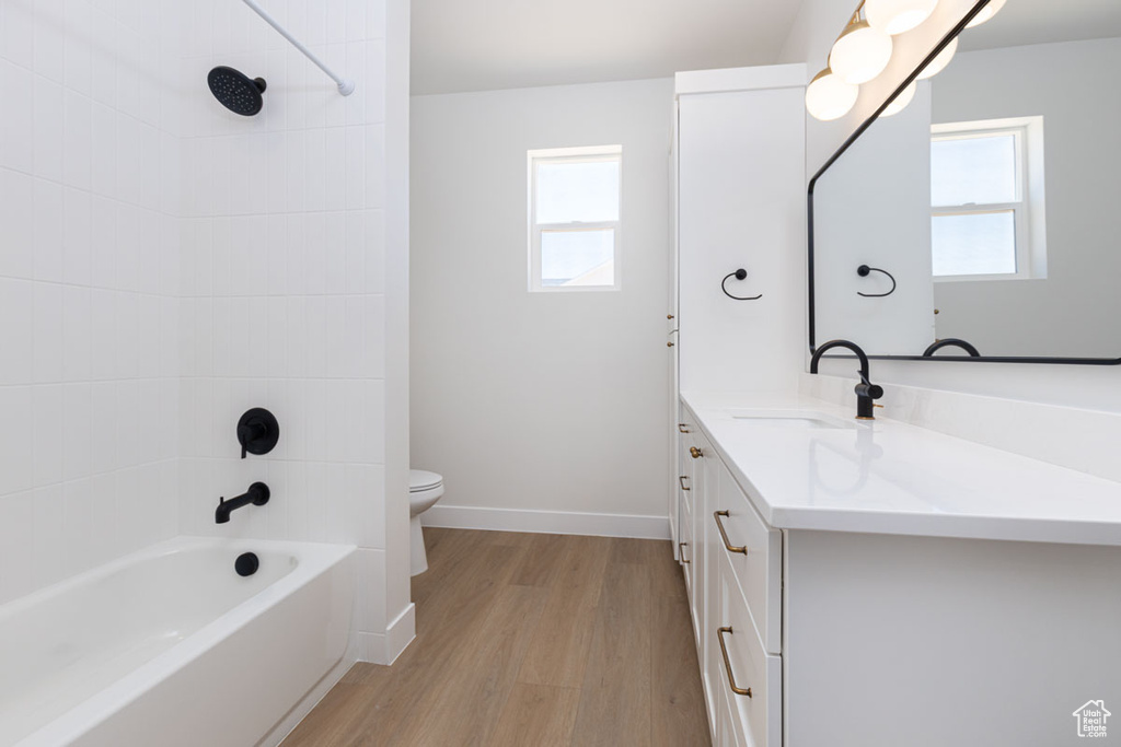Bathroom with wood finished floors, healthy amount of natural light, toilet, and vanity