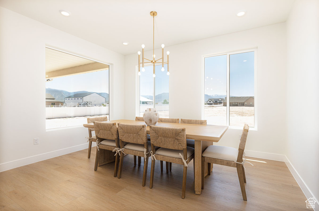 Dining room with a chandelier, light wood-style flooring, baseboards, and recessed lighting