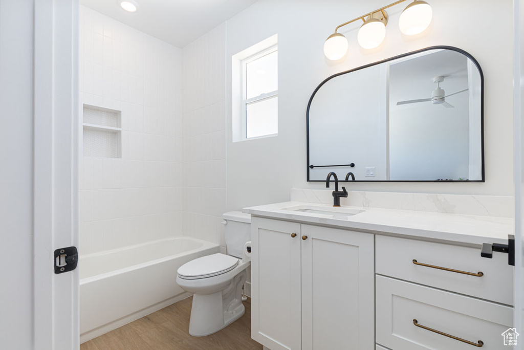 Full bathroom with wood finished floors, toilet, and vanity
