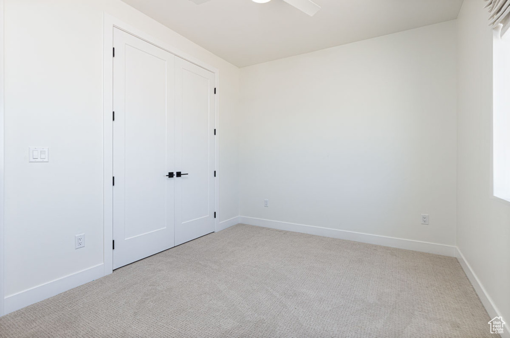 Unfurnished bedroom featuring carpet flooring, baseboards, and a closet