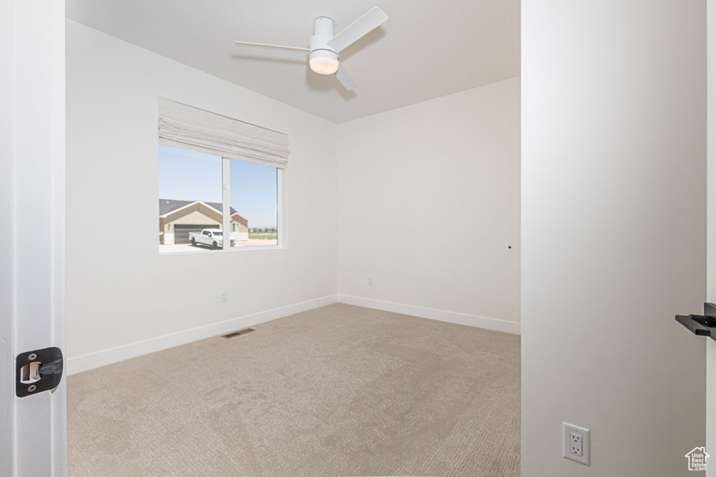 Unfurnished room featuring ceiling fan, carpet floors, and baseboards
