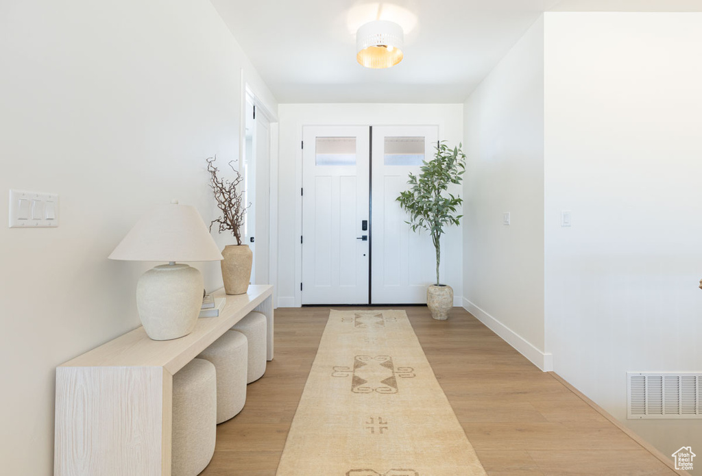 Entrance foyer with light wood-type flooring and baseboards