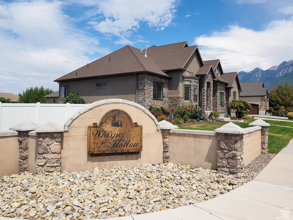 Community / neighborhood sign featuring fence and a mountain view