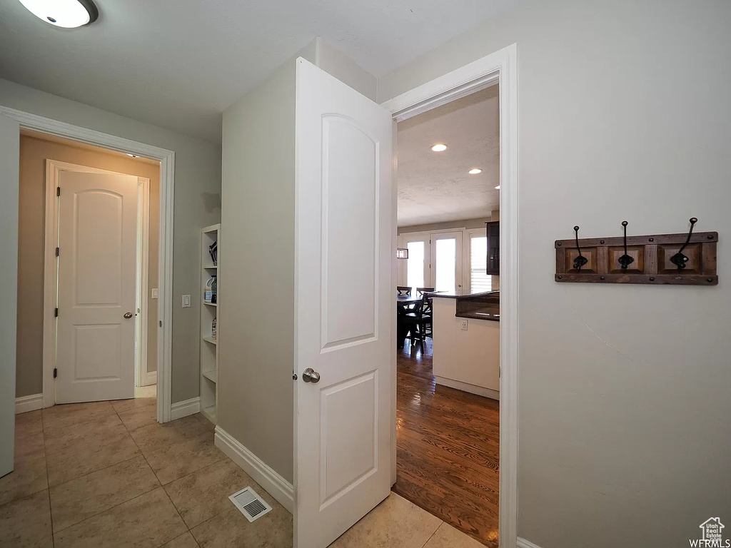 Corridor featuring light tile patterned floors, baseboards, and recessed lighting