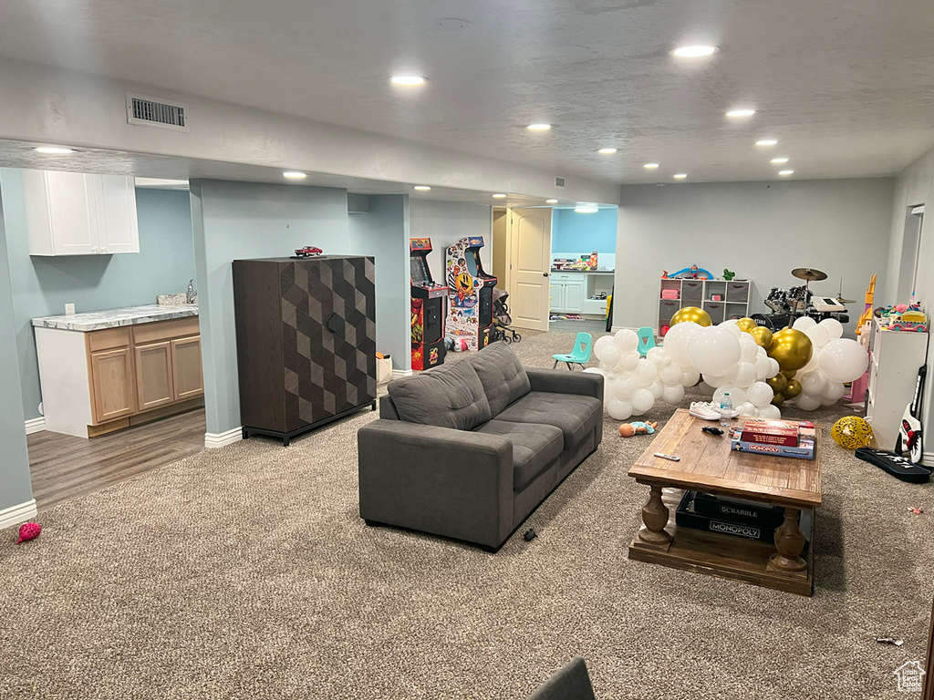 Living area with recessed lighting, light colored carpet, and baseboards