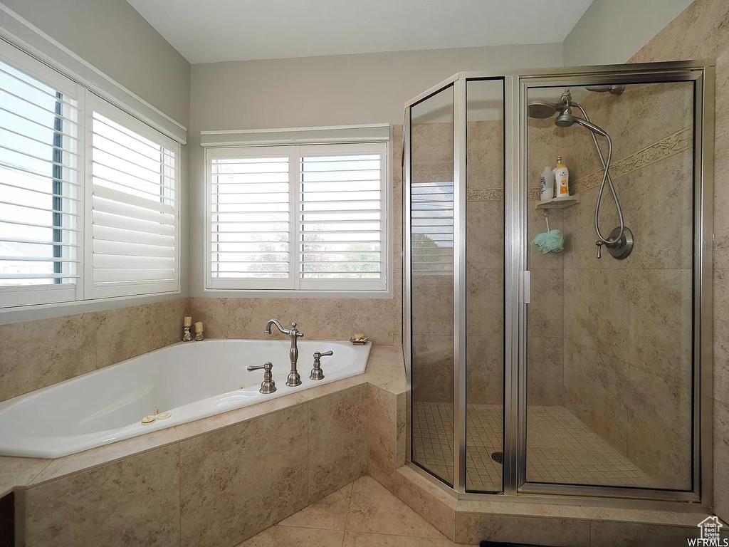 Bathroom with a stall shower, a garden tub, and tile patterned flooring