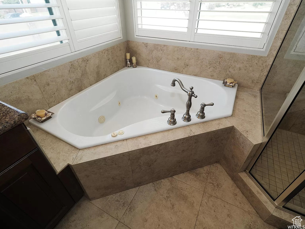 Full bathroom featuring a jetted tub and tile patterned floors