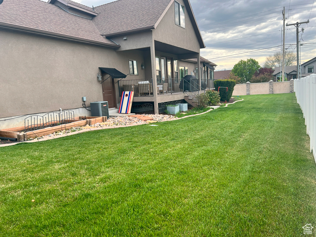 View of yard with a wooden deck and central AC