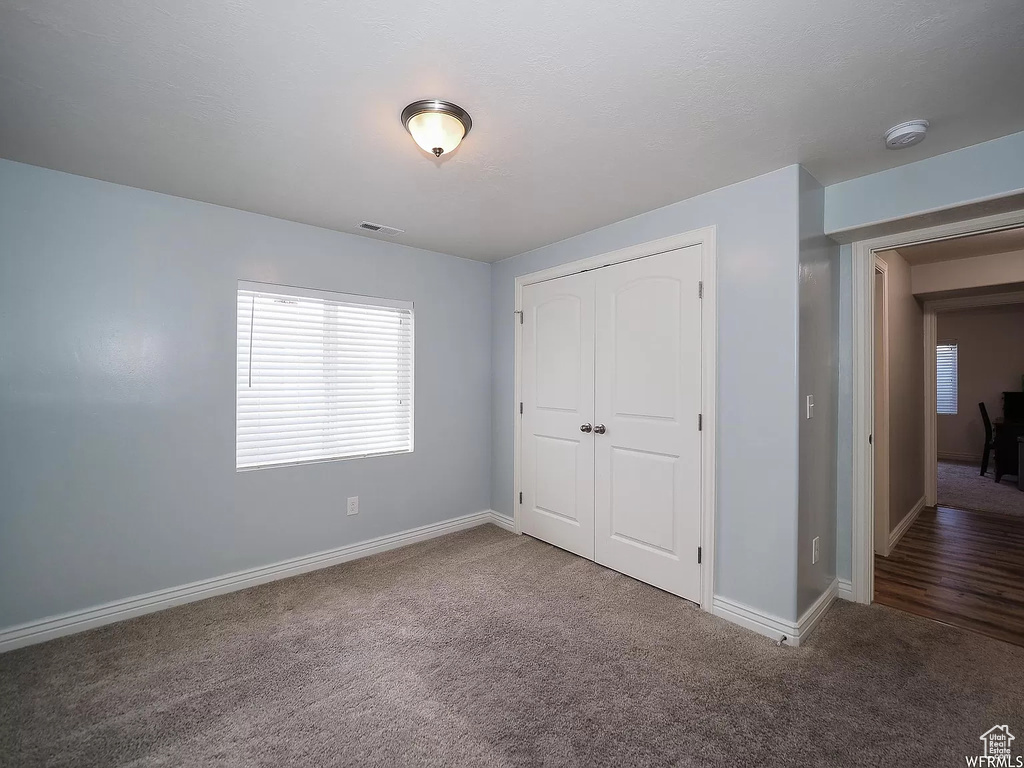 Unfurnished bedroom with carpet, baseboards, and a closet