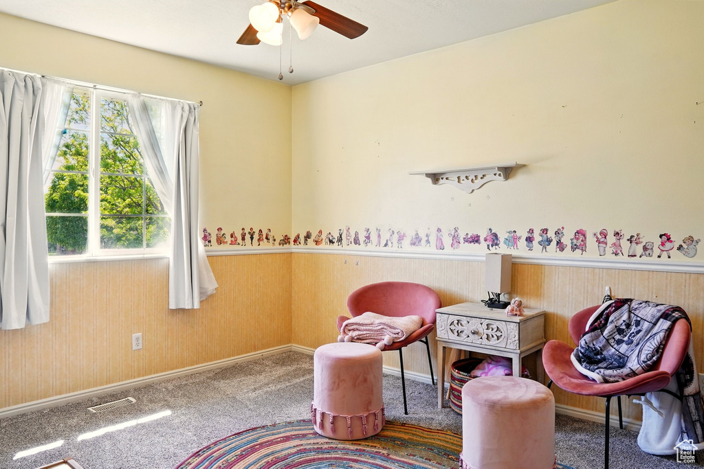 Sitting room with ceiling fan, carpet flooring, and baseboards