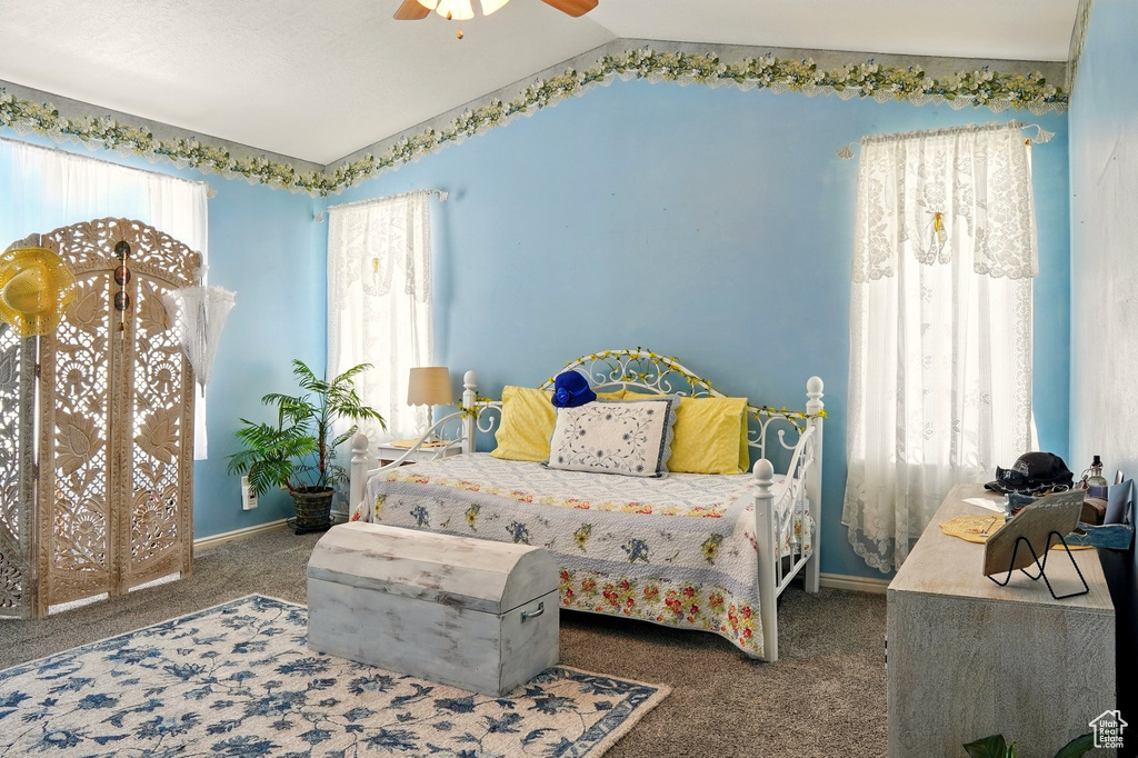 Carpeted bedroom with lofted ceiling, baseboards, and a ceiling fan