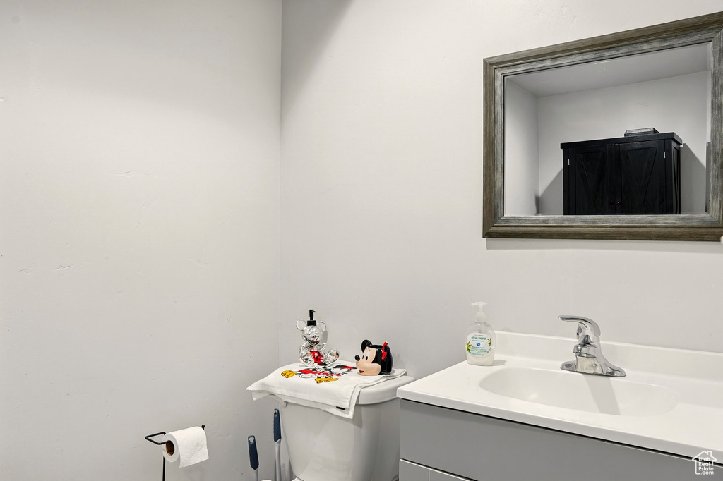 Half bathroom featuring vanity and toilet