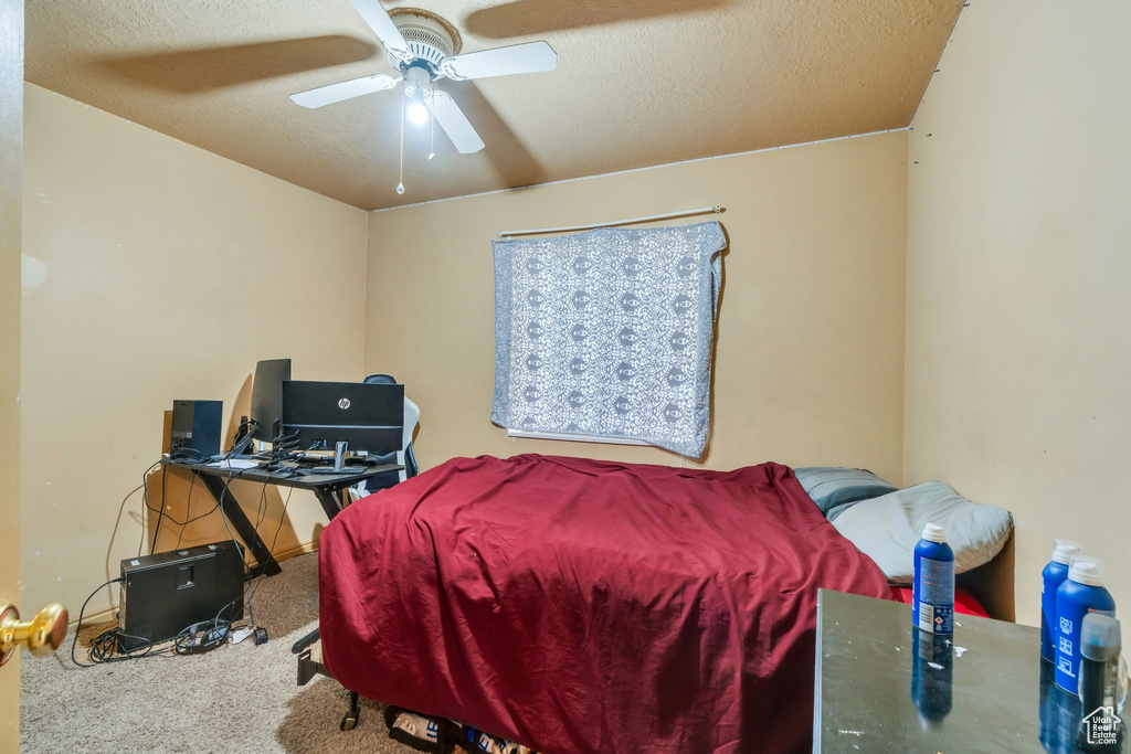 Bedroom featuring carpet floors, a textured ceiling, ceiling fan, and a desk