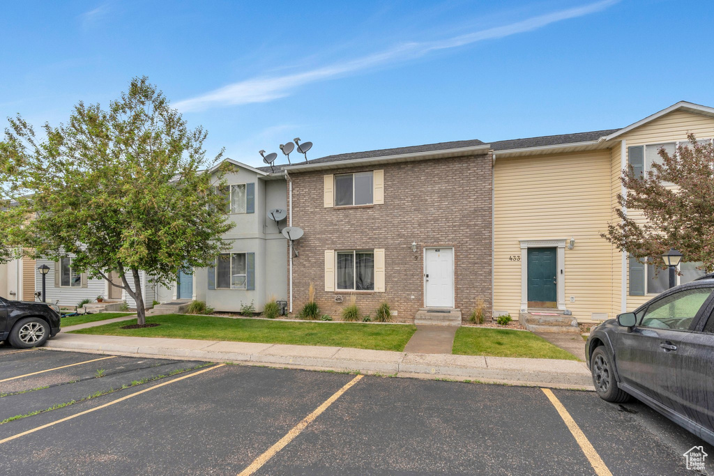 Multi unit property featuring uncovered parking and brick siding