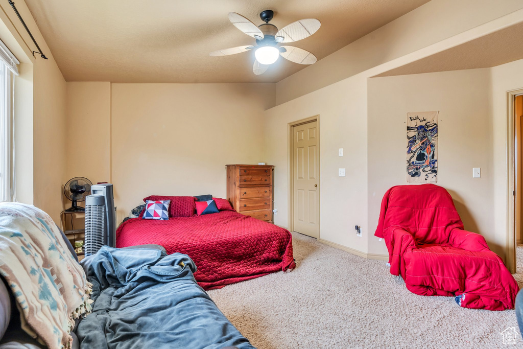 Carpeted bedroom featuring ceiling fan and baseboards