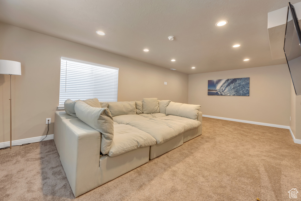 Carpeted living area featuring recessed lighting and baseboards