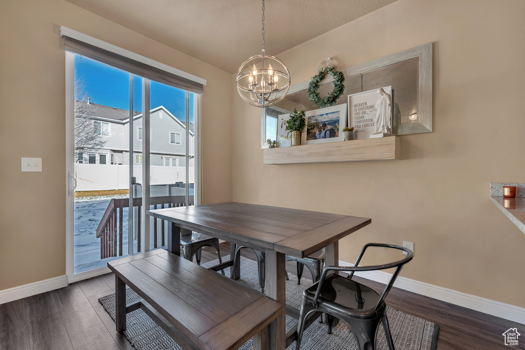 Dining room with a chandelier, baseboards, and wood finished floors