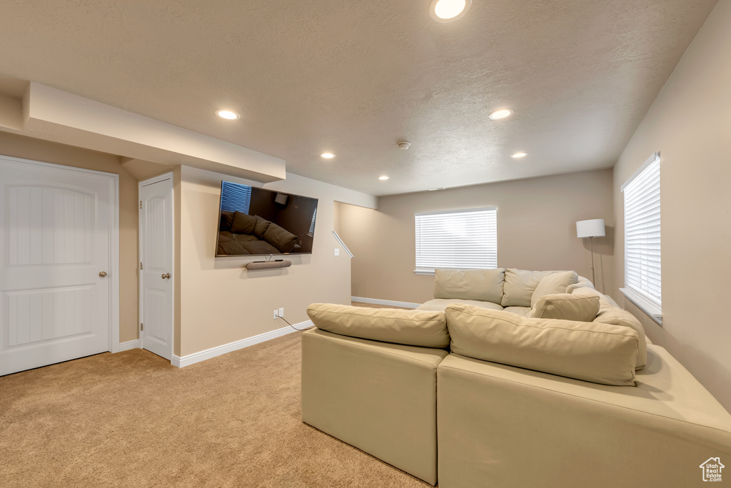 Living room featuring recessed lighting, light carpet, healthy amount of natural light, and baseboards