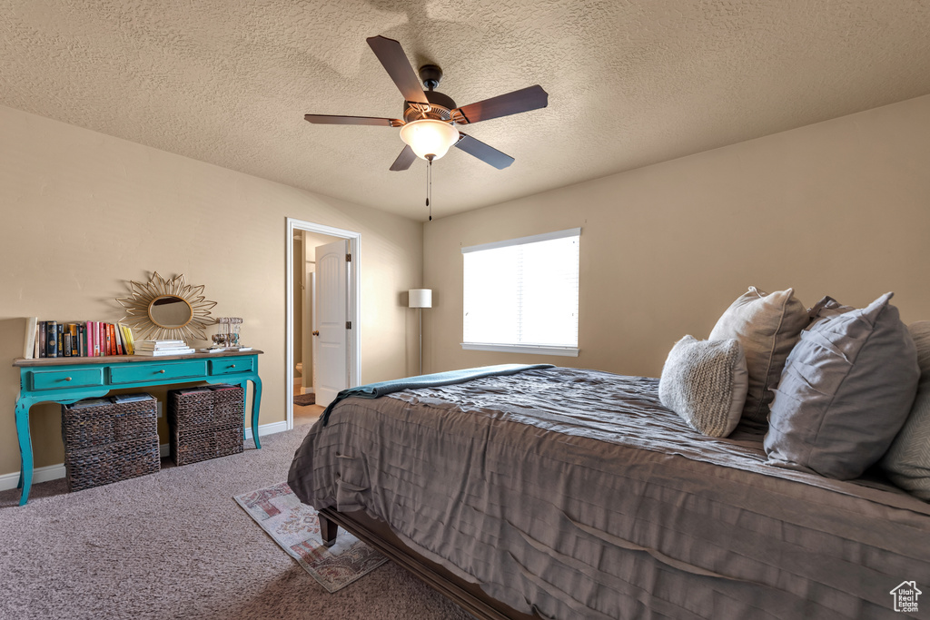 Carpeted bedroom with baseboards, a ceiling fan, and a textured ceiling