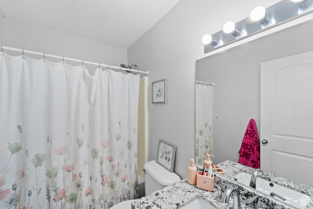 Full bath with vanity, toilet, and a shower with shower curtain