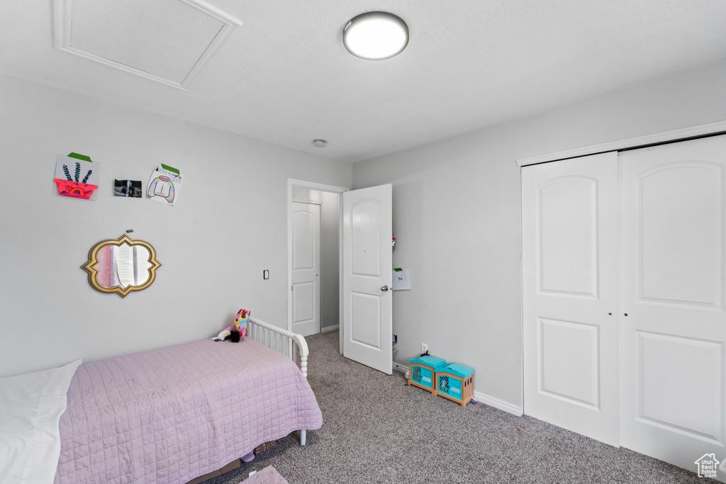 Carpeted bedroom with a closet and baseboards