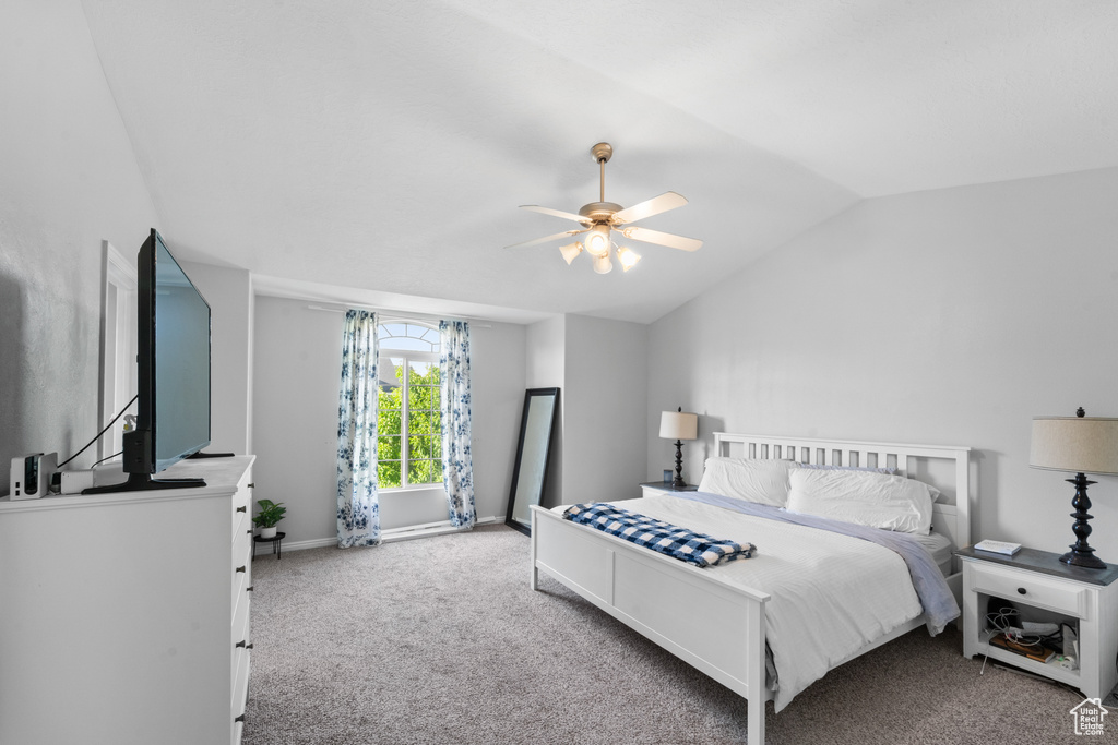 Bedroom featuring carpet flooring, lofted ceiling, baseboards, and a ceiling fan