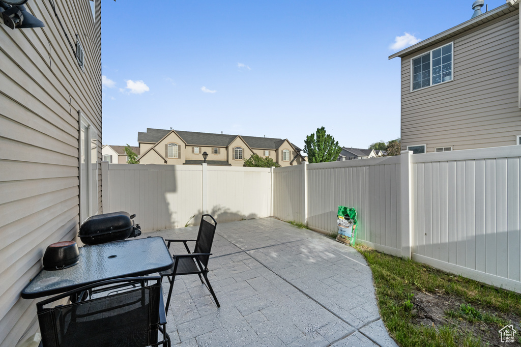 View of patio with outdoor dining area, a fenced backyard, and a residential view