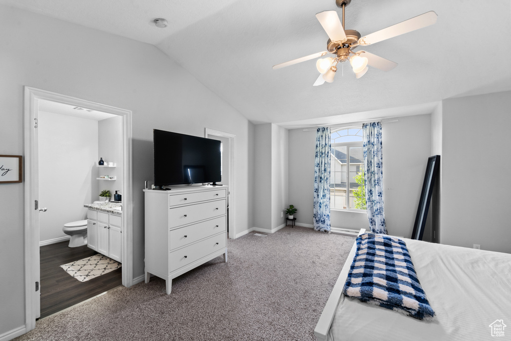 Bedroom featuring carpet, lofted ceiling, ensuite bath, baseboards, and ceiling fan