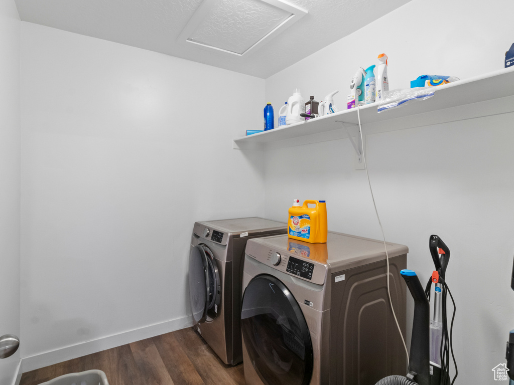 Washroom featuring separate washer and dryer, baseboards, dark wood finished floors, and attic access