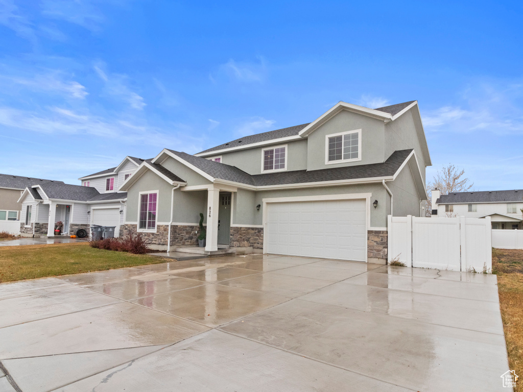View of front of property featuring stone siding, stucco siding, and an attached garage