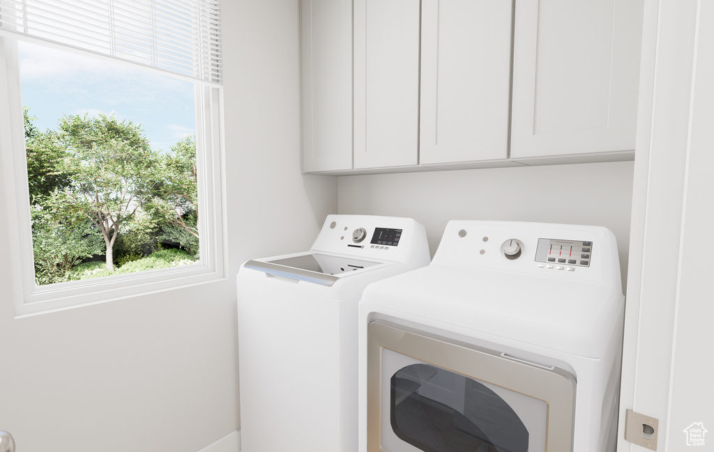Washroom featuring separate washer and dryer and cabinet space