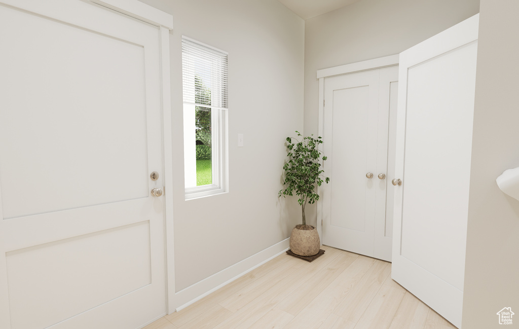 Doorway to outside featuring light wood-type flooring and baseboards