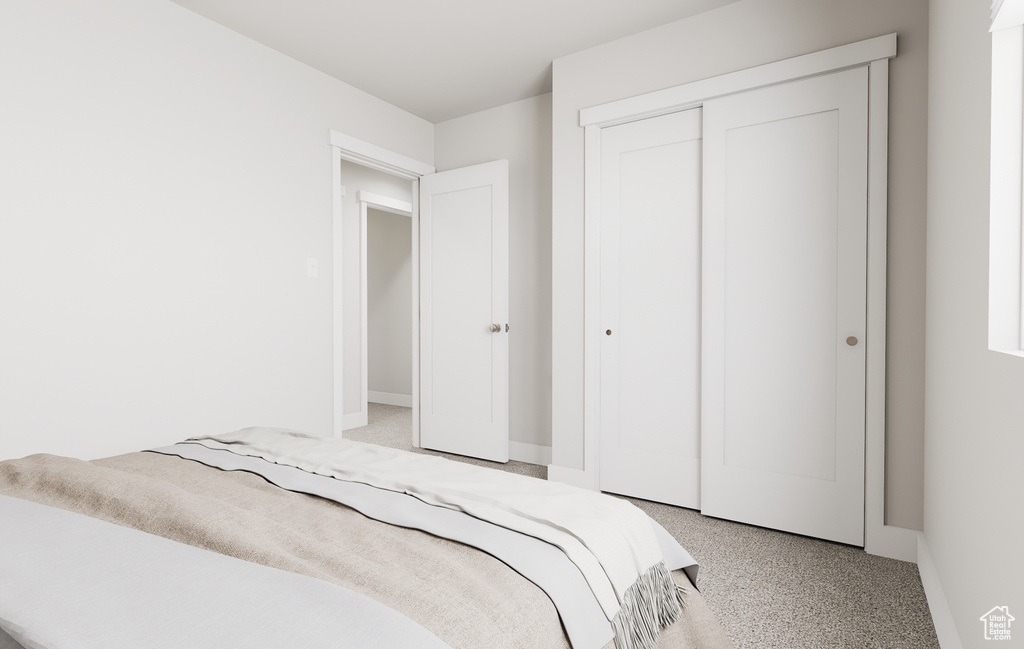 Bedroom with light colored carpet, baseboards, and a closet