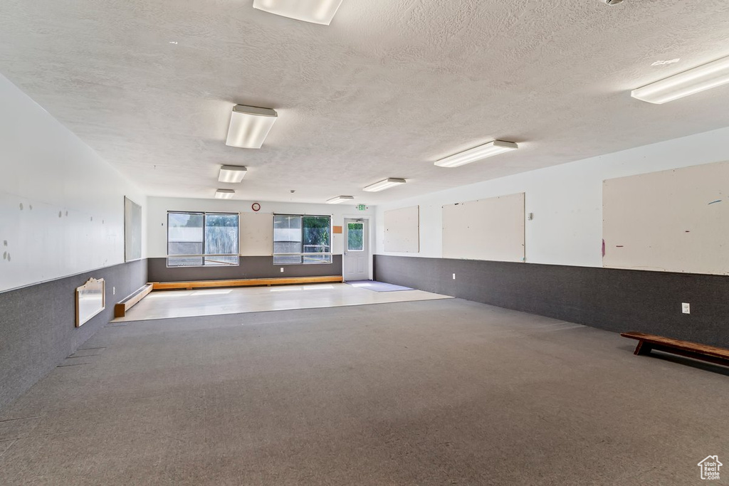 Empty room with a textured ceiling and carpet flooring