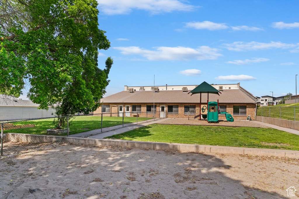 Rear view of house featuring brick siding and a playground