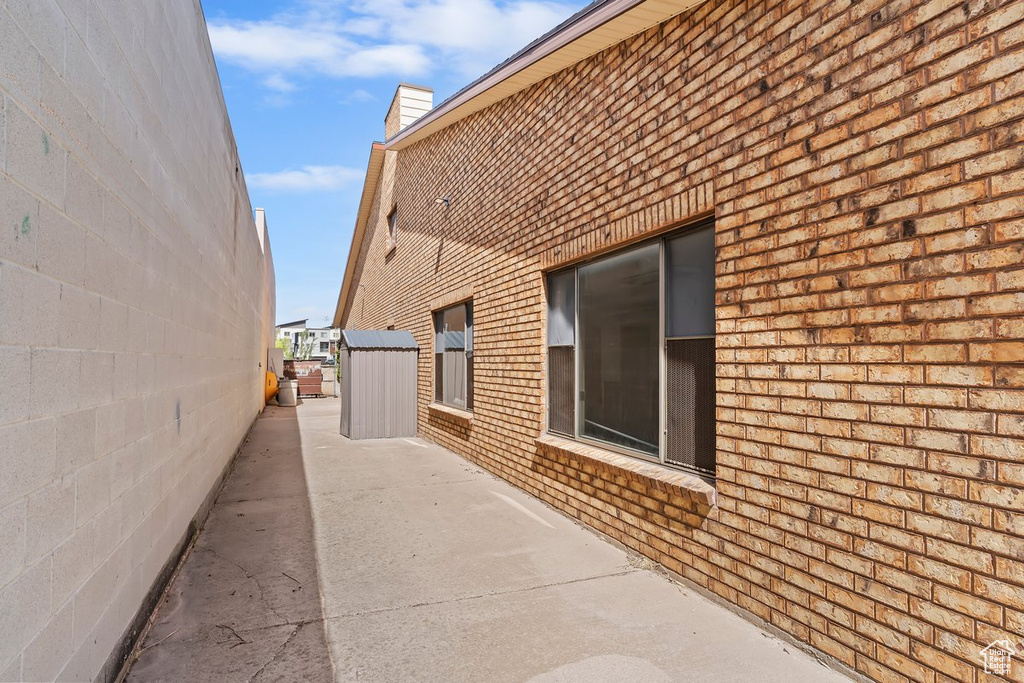 View of property exterior with brick siding and a chimney