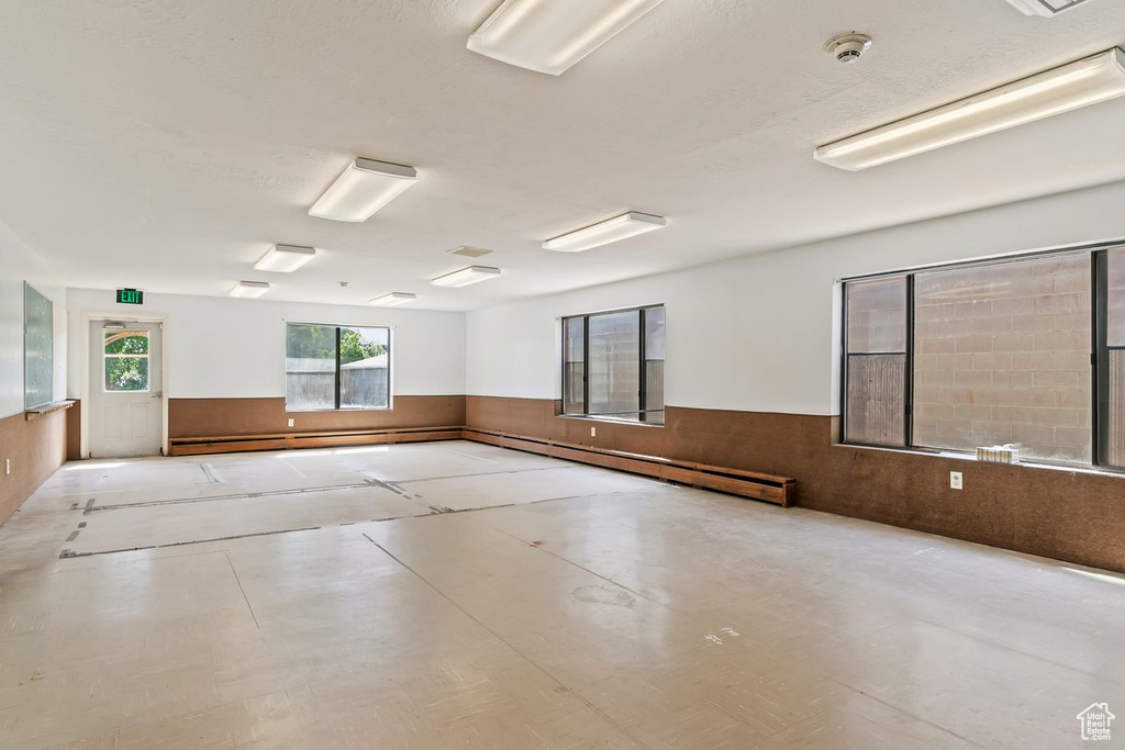 Unfurnished room with wainscoting, a smoke detector, and wood walls