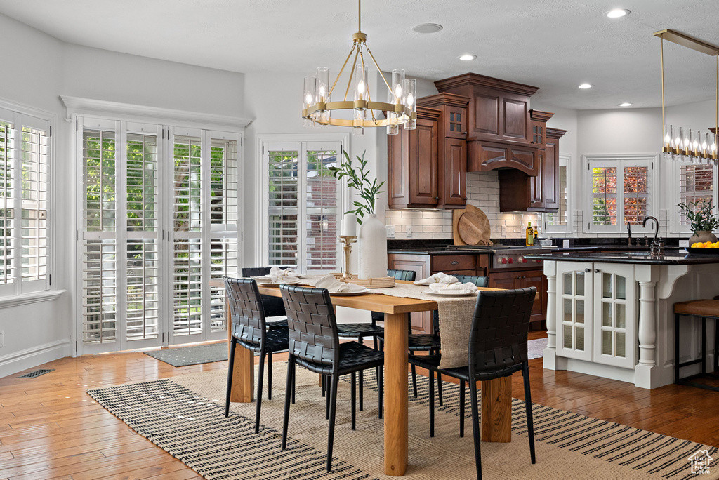 Dining area featuring a chandelier, light wood-style flooring, recessed lighting, and baseboards