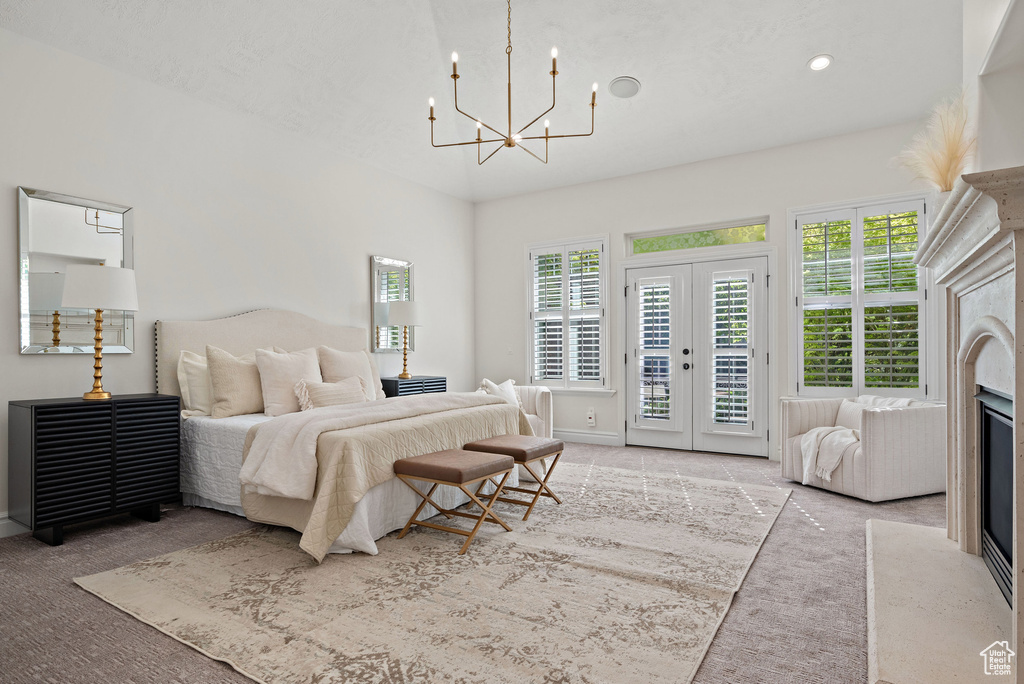Bedroom with access to exterior, carpet, a chandelier, and baseboards
