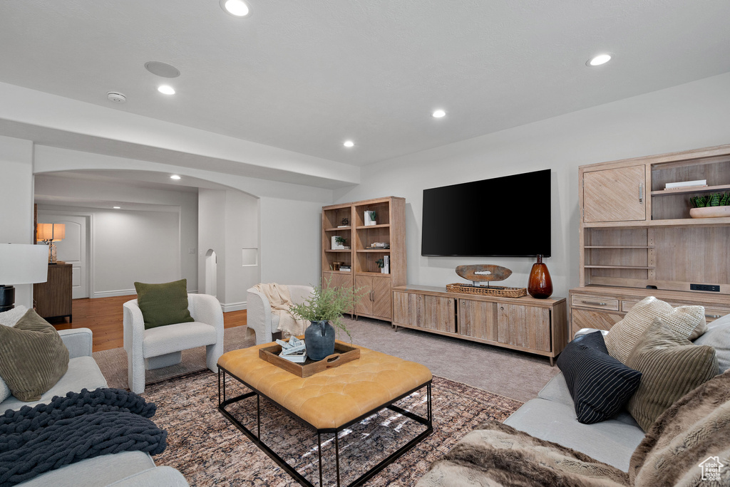 Living room featuring arched walkways, recessed lighting, and baseboards