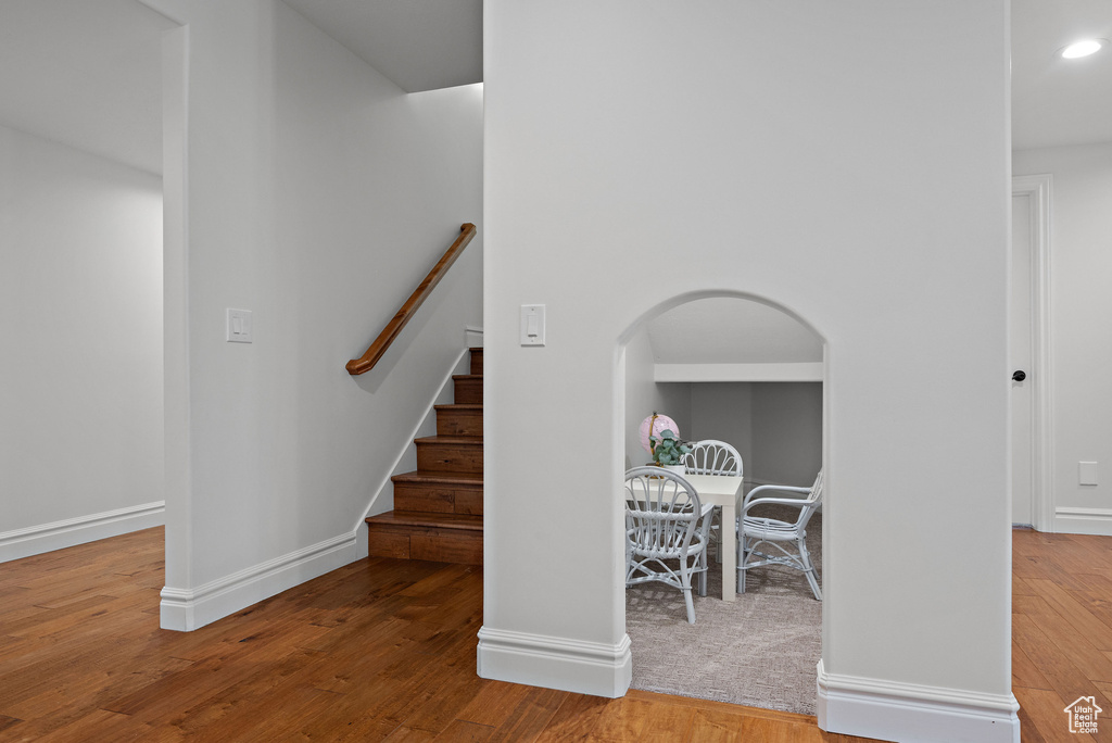 Entryway featuring wood finished floors, arched walkways, baseboards, and recessed lighting